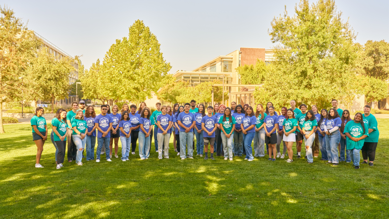 The full FYE team poses together on a grassy lawn in front of the Memorial Union.