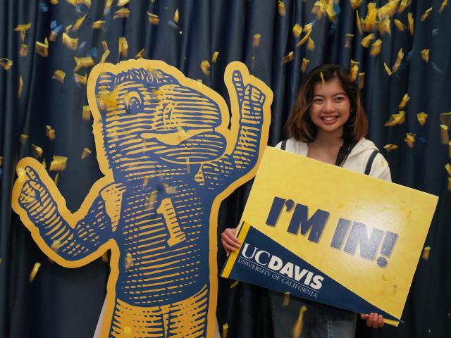 A student poses with a Gunrock cut-out and a sign reading "I'm In!"