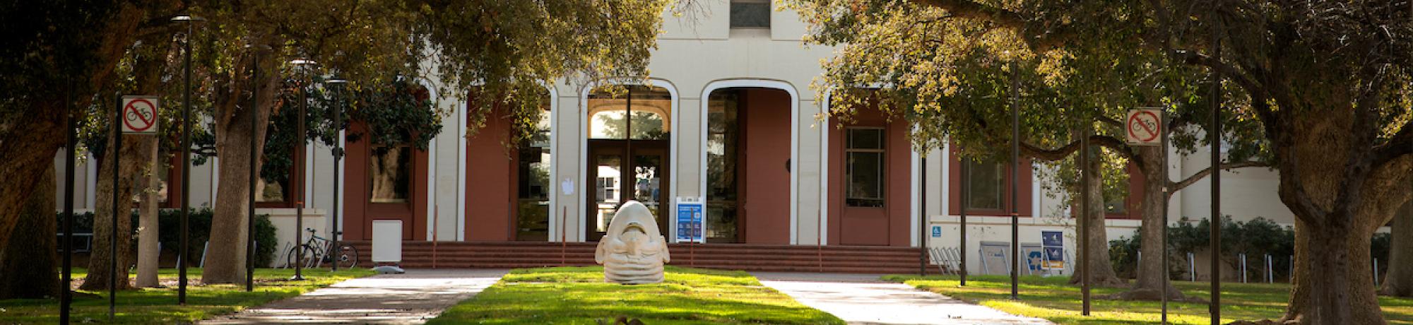 The egghead statue in front of Mrak Hall, on a sunny day.