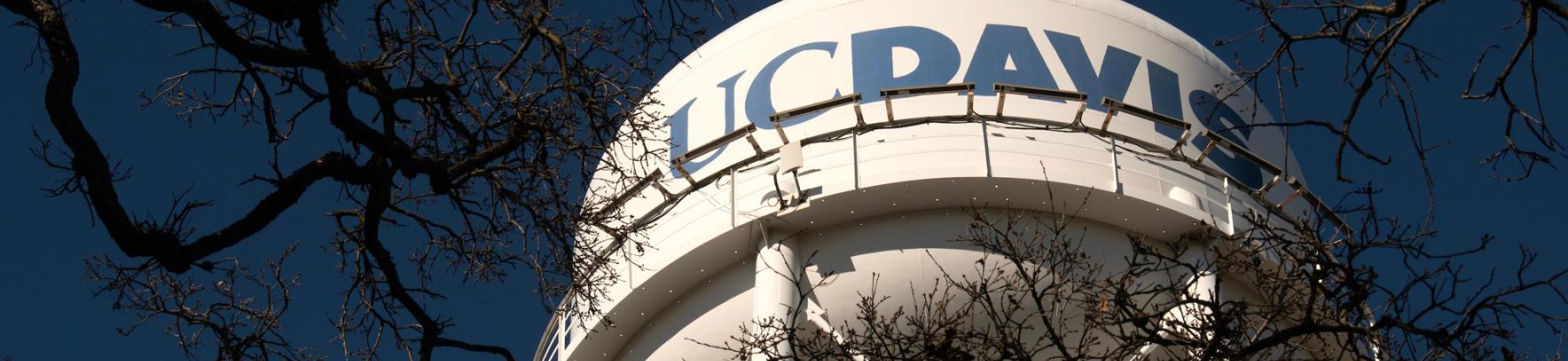 The UC Davis water tower against a dark blue sky.