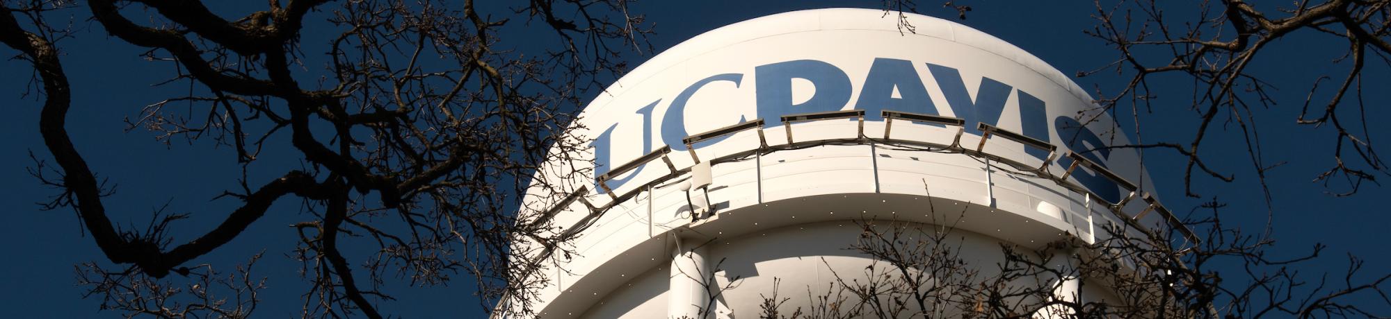 The UC Davis water tower against a dark blue sky.