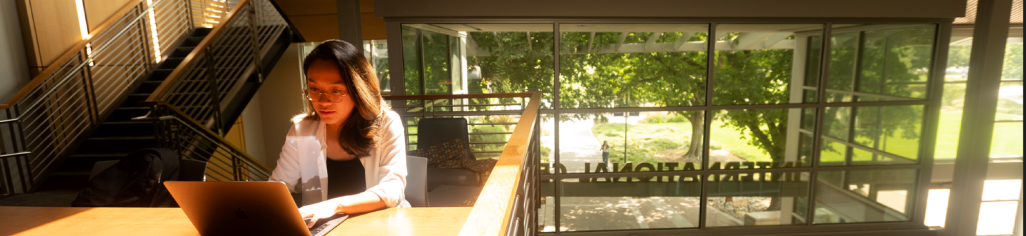 A student uses their laptop in the International Center.