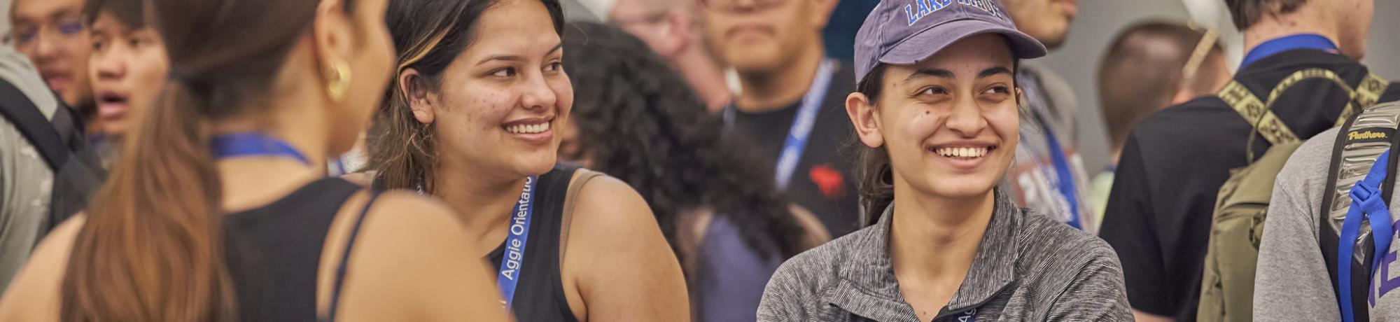Three students talk and smile.